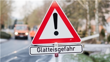 Schild mit Warnung vor Glatteisgefahr 
