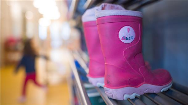 Kinder-Gummistiefel im Regal einer Kita.