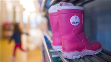 Kinder-Gummistiefel im Regal einer Kita.