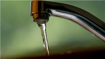 Wasser fließt aus einem Wasserhahn. 