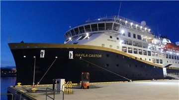 Ein Schiff liegt an der Schiffsleine im Hafen. 
