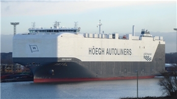 Ein großes Autotransportschiff der Reederei Höegh Autoliners mit dem Namen „Höegh Sunlight“ in einem Hafen. Das Schiff ist weiß und grau lackiert und trägt die Aufschrift „LNG Powered“.