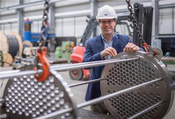 Die J.H.K. Gebäudetechnik an der Labrador-Straße: Julius Kramer in der Halle zur Edelstahlverarbeitung mit einer Komponente für einen Wärmetauscher. 