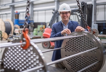 Die J.H.K. Gebäudetechnik an der Labrador-Straße: Julius Kramer in der Halle zur Edelstahlverarbeitung mit einer Komponente für einen Wärmetauscher. 