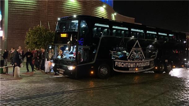 Menschen steigen in Bus ein.