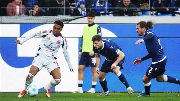 Die KSC-Spieler Leon Jensen (m) und Sebastian Jung (r) attackieren den Düsseldorfer Myron van Brederode (l).