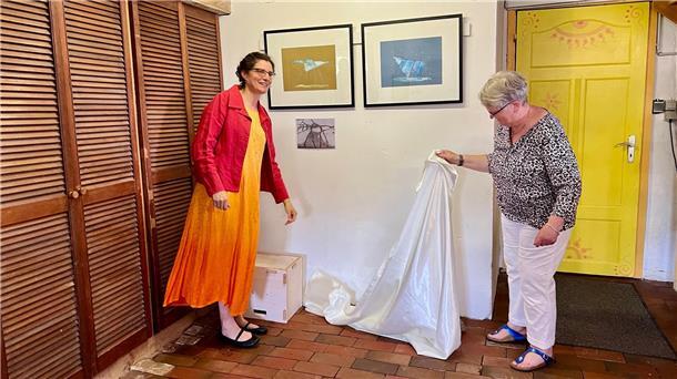 Zwei Frauen enthüllen Bilder in Ausstellung