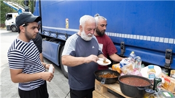 Die Lastwagenfahrer an der südhessischen Autobahnraststätte haben eine Palette  zu einem provisorischen Tisch für ihr Abendbrot umfunktioniert.