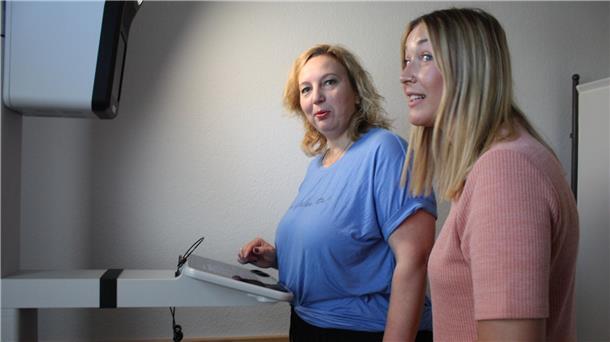 Zwei Frauen stehen im Bürgeramt am PointID-Gerät. Eine von ihnen bedient das Display, die andere steht beratend daneben.
