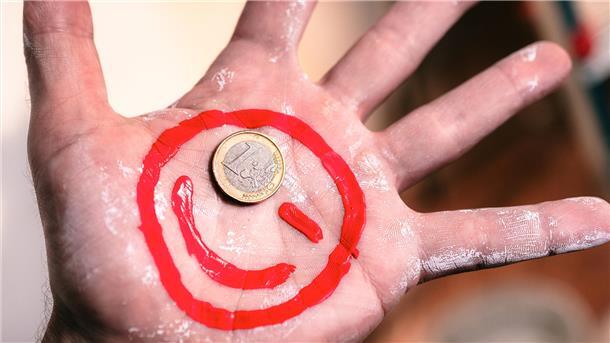 Ein Maler-Euro-Smiley auf eine Hand gemalt.