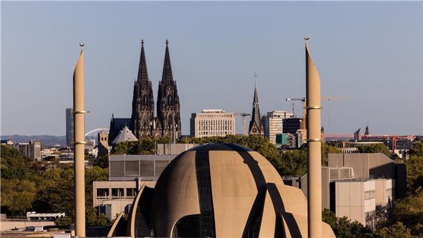 Die Minarette der Zentralmoschee der DITIB ragen vor den Türmen des Kölner Doms in den Himmel.