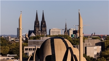 Die Minarette der Zentralmoschee der DITIB ragen vor den Türmen des Kölner Doms in den Himmel.