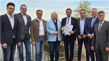 Sieben Männer und eine Frau stehen nebeneinander.