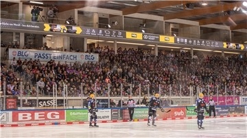 Drei Eishockey-Spieler stehen auf dem Eis. Oberhalb der Eisfläche sind neue Logen in der Eisarena Bremerhaven zu sehen.