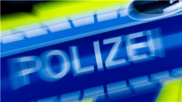 Schriftzug „Polizei“ auf einem Streifenwagen.