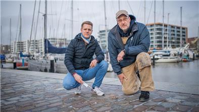 Die Oberfläche der Fugen bröckelt an vielen Stellen am Neuen Hafen. Projektleiter Tim Thyen von der Bremerhavener Entwicklungsgesellschaft Alter/ Neuer Hafen (links) lässt sich die Schäden von „Im Jaich“- Haustechniker Lars Fröhlich zeigen.