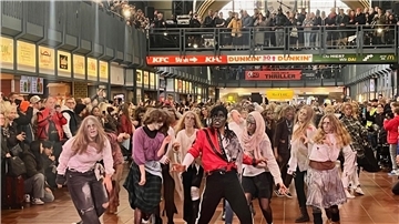 Menschen als Zombies verkleidet tanzen zum Michael-Jackson-Hit "Thriller" im Hamburger Hauptbahnhof.