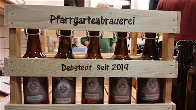 In einer Holzkiste stehen Bierflaschen.