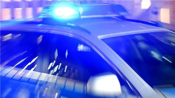 Ein Streifenwagen der Polizei steht mit eingeschaltetem Blaulicht auf der Straße.