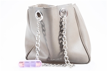 Eine helle Handtasche und eine lilafarbene Pillendose