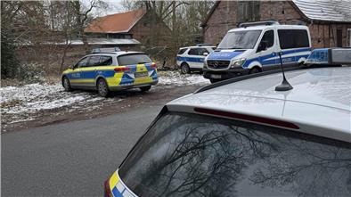 Mehrere Polizeifahrzeuge stehen an einer Straße.