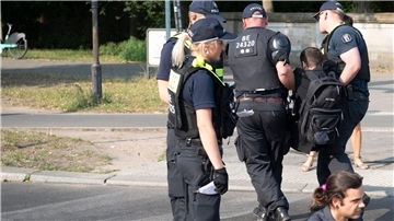 Die Polizei trägt einen Aktivisten der Gruppe Letzte Generation weg, der mit anderen die Fahrbahnen rund um die Siegessäule in Berlin blockiert hat.