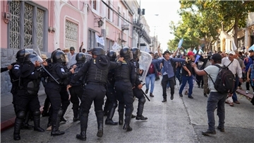 Die Polizei versucht, Anhänger des gewählten guatemaltekischen Präsidenten Arévalo zurückzuhalten, die vor dem Kongress in Guatemala-Stadt gegen eine Verzögerung des Beginns der Legislaturperiode protestieren.