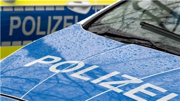 Eine blaue Motorhaube eines Autos und der Schriftzug Polizei.