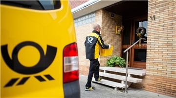 Ein Zusteller bringt Post an eine Haustür