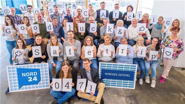 Eine große Gruppe von Menschen hält Buchstaben hoch. Sie ergeben den Text: "@MOSAiCArctic Good luck & Safe trip".