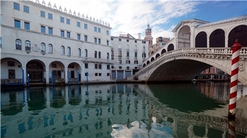 Die Rialto-Brücke spiegelt sich im Canal Grande.