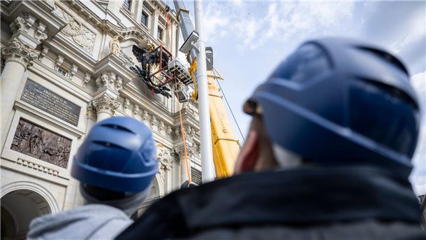 Die riesige Kartusche mit Wappen wird über dem Eosander-Portal, dem Haupteingang der rekonstruierten barocken Schlossfassade, mit Hilfe von Kran und Fassadenkletterern angebracht.