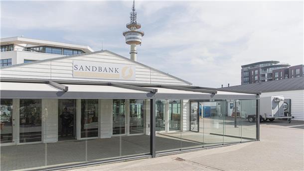 Weserstrandbad Bremerhaven: Was Besucher wissen müssen Blick auf ein Gebäude. Die Sandbank präsentiert sich mit neuer Terrasse und Glasfront.