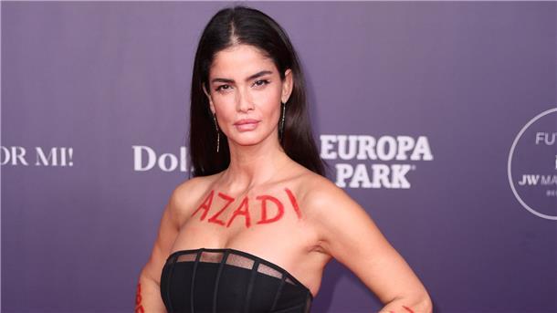 Die Schauspielerin Shermine Shahrivar kommt zur Charity-Veranstaltung „Tribute to Bambi“ und hat den Namen „AZADI“ und den Schriftzug „Freedom“ auf Arme und Dekoltee geschrieben.