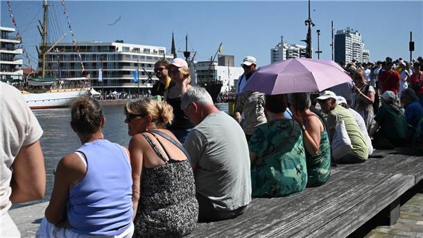 Menschen auf einer Bank am Wasser.