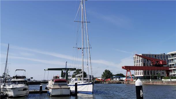 Blick auf ein Hafenbecken mit einer Segelyacht.