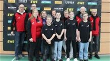 Erwachsene und Kinder blicken in die Kamera.