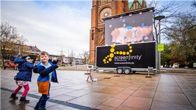 Die sensorgesteuerte Lichtleinwand vor der Großen Kirche reagiert auf die Bewegung von Marie und Max Kahle aus Geestenseth.