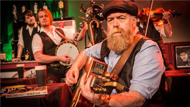 Kultur auf dem Silbertablett: So macht es der Bürgerverein Stollhamm möglich Ein bärtiger Mann mit Gitarre. Das Foto zeigt eine Szene aus der Show „Seven drunken Nights".