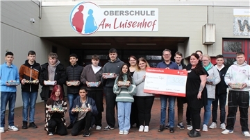 Jugendliche und Erwachsene vor einer Schule