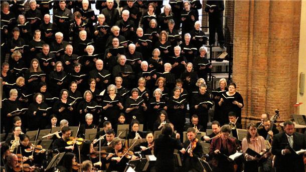Viele Menschen spielen Musik in einer Kirche. 