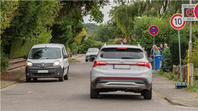 B71-Sanierung in Bexhövede: Bürger sieht „geduldetes Wild West“ Eine Straße, auf der Autos fahren. Im Hintergrund ist ein Tempo-10-Schild zu sehen. Außerdem ein Tempotafel mit einem traurigen Smiley.