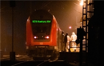  Mitarbeiter der Spurensicherung sind auf einem Bahnsteig an einem Regionalzug im Einsatz. 