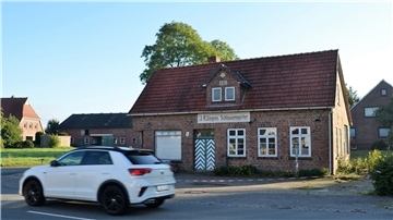 Ein Auto fährt an der alten Schlosserei in Köhlen vorbei.