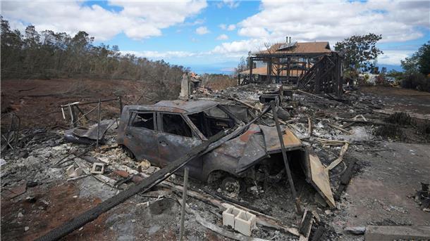 Fast 100 Tote nach Feuerkatastrophe auf Maui Die verkohlten Überreste eines Fahrzeugs stehen in Kula neben einem von einem Waldbrand zerstörten Haus.