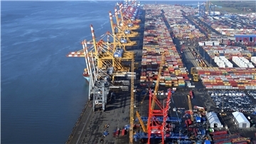 Containerbrücken am Fluss, Luftaufnahme