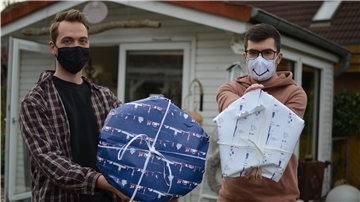 Die Volontäre Jannik Sauer (links) und Florian Zinn haben ihre Geschenke um die Wette eingepackt. Sie hatten 13 Minuten Zeit, einen Kranz und einen Stern einzupacken.