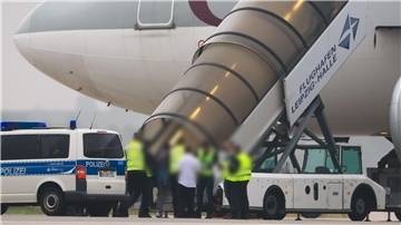 Abschiebungen aus Bremerhaven und Bremen verdreifacht: Fragen nach Polizeigewalt Polizisten begleiten Personen in ein Flugzeug.