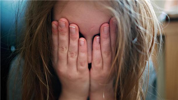 Schulen im Landkreis Cuxhaven: Gewalt nimmt zu  Ein junges Mädchen hält sich die Hände vor ihr Gesicht.