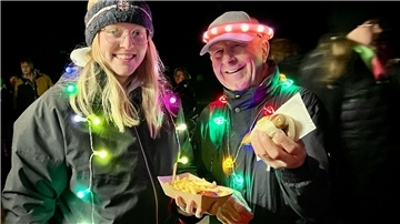 Eine Frau und ein Mann mit Lichterketten beim „Strandleuchten“ in Burhave.